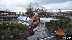 ຜູ້ຊາຍຄົນນຶ່ງ ນັ່ງຢູ່ເທີງກອງຊາກຫັກພັງ ທີ່ໄດ້ຮັບຄວາມເສຍຫາຍ ຫຼັງຈາກໄຕ້ຝຸ່ນ Haiyan ພັດຖະຫຼົ່ມ ໃນມື້ວັນສຸກວານນີ້ ທີ່ເມືອງ Tacloban ໃນເຂດພາກກາງ ຂອງຟິລິບປິນ (9 ພະຈິກ 2013)