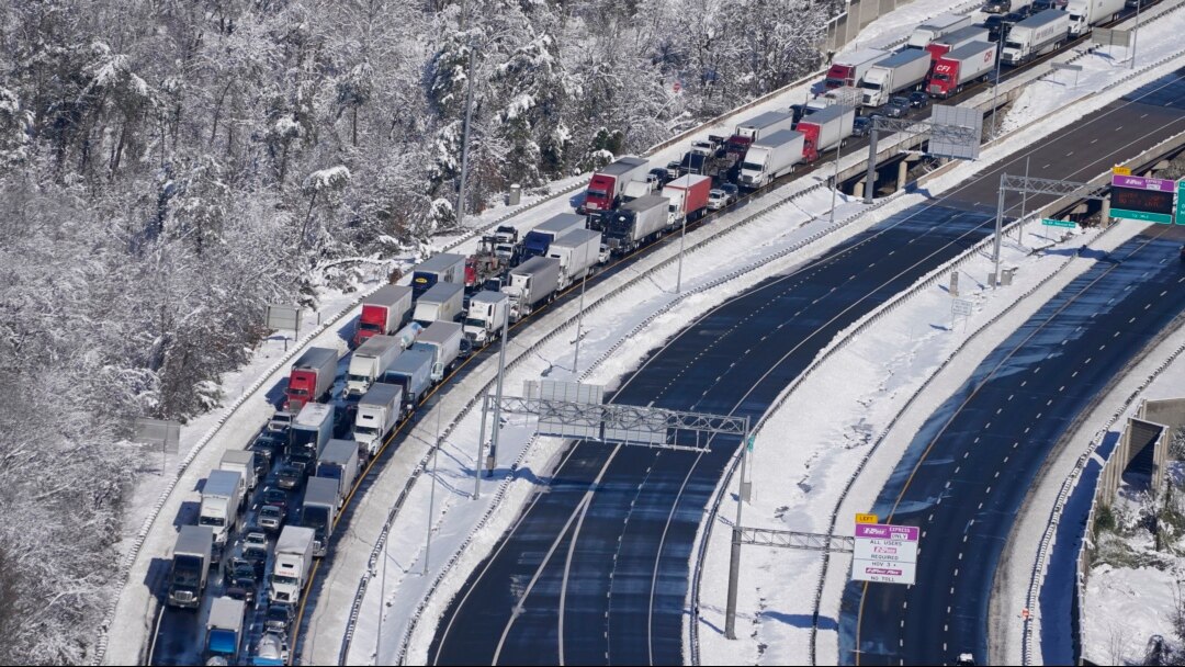 Mobil dan truk tejebak di Interstate 95, dekat Quantico, Virginia, Selasa, 4 Januari 2022. Hampir 48 mil jalan tol Interstate di negara bagian Virginia, ditutup akibat es dan salju. (AP/Steve Helber)
