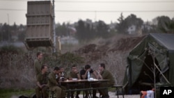 Binh sĩ Israel ngồi cạnh hệ thống phòng thủ phi đạn 'Vòm Sắt' ở Tel Aviv, ngày 17/11/2012.
