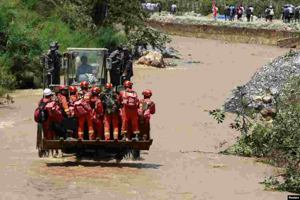 Rescue workers are transported to an earthquake zone on a front loader in Zhaotong, Yunnan province, Aug. 5, 2014.