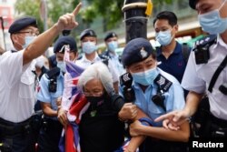 A pro-democracy protester with a Union flag mask is taken by police at Causeway Bay after police denied permission for a protest rally during the 24th anniversary of the former British colony’s return to Chinese rule, on the 100th founding anniversary of the Communist Party of China, in Hong Kong, China July 1, 2021. REUTERS/Tyrone Siu