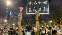 六四31周年香港人首次进行”非法”维园烛光悼念集会，数以万计市民响应，有人高举烛光及标语 （美国之音汤惠芸拍摄）