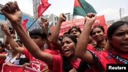 FILE - Garment workers and activists shout slogans during a rally in Dhaka May 1, 2014.