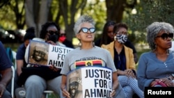 Personas con carteles se reúnen frente al Palacio de Justicia del Condado de Glynn por el juicio por el asesinato de Ahmaud Arbery, en Brunswick, Georgia, Estados Unidos, el 18 de octubre de 2021.