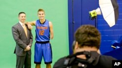 Florida head coach Mike White poses for a photo with Florida guard Zach Hodskins (12) Sept. 29, 2015, in Gainesville, Fla. Hodskins plays basketball with only one arm. (AP Photo/John Raoux)