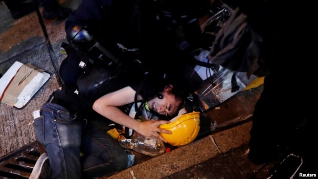 香港防暴警察2019年7月28日在北京驻港中联办附近拘捕一名示威者。