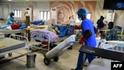 Un responsable de la santé pousse une bouteille d'oxygène sur un chariot pour traiter des patients atteints de COVID-19 souffrant de problèmes respiratoires aigus dans un service du centre d'isolement de l'État de Lagos à Yaba, Lagos, le 22 janvier 2021.