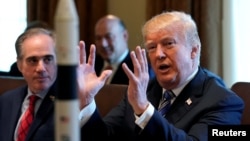 With a rocket ship on the table, U.S. President Donald Trump speaks during a cabinet meeting at the White House in Washington, March 8, 2018. 