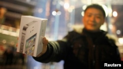 A customer show his new iPhone 4S after making the purchase at Apple's retail store in downtown Shanghai, January 13, 2012.
