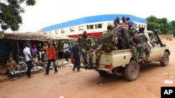 FILE - Militias of the Seleka alliance drive past stalls at the central market in Bangui, Central African Republic, in March, 2013.