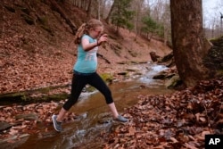 Charity plays behind the house where she lives with her grandmother, Maggie Hill, in Madison, W.Va., on Thursday, Nov. 29, 2018. (AP Photo/Tyler Evert)