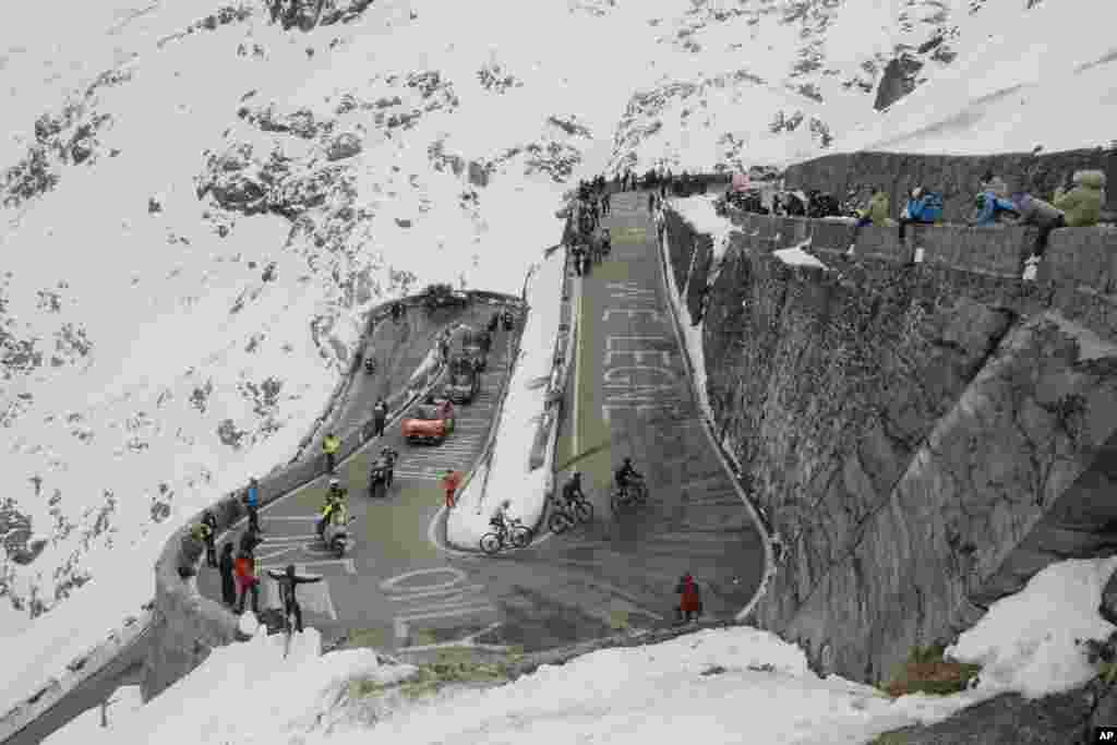 Cyclists pedal along hairpin bends as they climb the Stelvio Pass, 2,757 meters (9,045 ft) above sea level, during the 18th stage of the Giro d'Italia cycling race from Pinzolo to Laghi di Cancano, northern Italy, Thursday, Oct. 22, 2020. (Fabio Ferrari/L