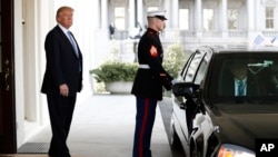President Donald Trump stands in the entrance of the the West Wing of the White House in Washington, Feb. 15, 2017, with a limousine standing in the portico.