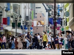 Para pejalan kaki mengenakan masker saat berjalan di pusat kota Tokyo, Jepang, di tengah pandemi COVID-19, di 14 Mei 2021. (REUTERS / Naoki Ogura)