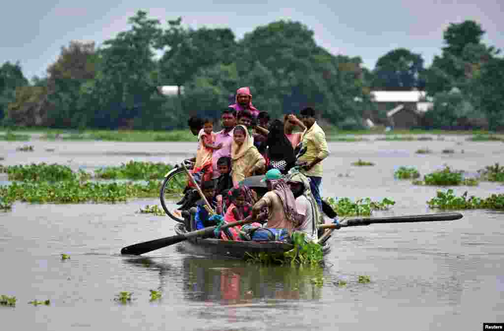 Flood affected villagers are transported on a boat towards a safer place at a village in Morigaon district, in the northeastern state of Assam, India.