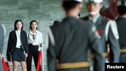 FILE - Two Chinese university students from Beijing watch military guards at Taipei's Sun Yat-sen Memorial Hall exchange their hour-long shift. 