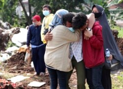 Anggota keluarga saat pemakaman kerabatnya di Pemakaman Srengseng Sawah yang diperuntukkan bagi mereka yang meninggal karena COVID-19, di Jakarta, Rabu, 9 Juni 2021. (Foto: AP/Tatan Syuflana)