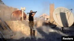 An American volunteer fighter of Syrian Democratic Forces fires an RPG during a battle with Islamic State militants in Raqqa, Syria, Oct. 6, 2017. An American surrendered to US-backed fighters in Syria in mid-September and is being held as an unlawful com