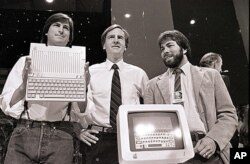 FILE - Steve Jobs, left, John Sculley, center, and Steve Wozniak, co-founder of Apple, unveil the new Apple II computer in San Francisco on April 4, 1984.