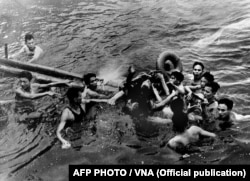 A photo taken 26 October 1967 shows US Navy Airforce Major John McCain (C) being rescued from Hanoi's Truc Bach lake by several Hanoi residents after his Navy warplane was downed by Northern Vietnamese army during the Vietnam War.