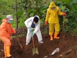 Bupati Banyumas Achmad Husein (putih) ikut memindah jenazah untuk menekan ketakutan warga terhadap pemakaman korban virus corona. (Foto: Pemkab Banyumas)