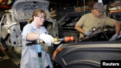 FILE - Ford assembly workers attach a head light to a Ford Focus at the Ford assembly plant in Wayne, Michigan October 15, 2007. 