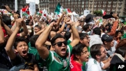 Para pendukung tim Meksiko merayakan kemenangan timnya dalam pertandingan Piala Dunia melawan Jerman, saat mereka menyaksikan pertandingan itu di layar luar ruang di Mexico City, Meksiko, 17 Juni 2018 (foto: AP Photo/Anthony Vazquez)
