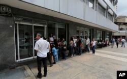 Customers lineup outside of a bank to get cash, in Caracas, Venezuela, Sept. 23, 2017.