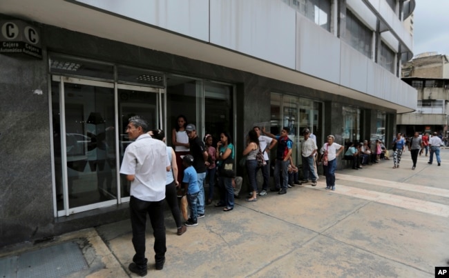 Customers lineup outside of a bank to get cash, in Caracas, Venezuela, Sept. 23, 2017.