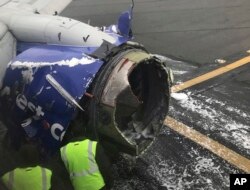 The engine on a Southwest Airlines plane is inspected as it sits on the runway at the Philadelphia International Airport after it made an emergency landing in Philadelphia, April 17, 2018