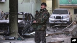 An Afghan security forces member stands guard at the Spanish Embassy after an attack in Kabul, Afghanistan, Dec. 12, 2015. 