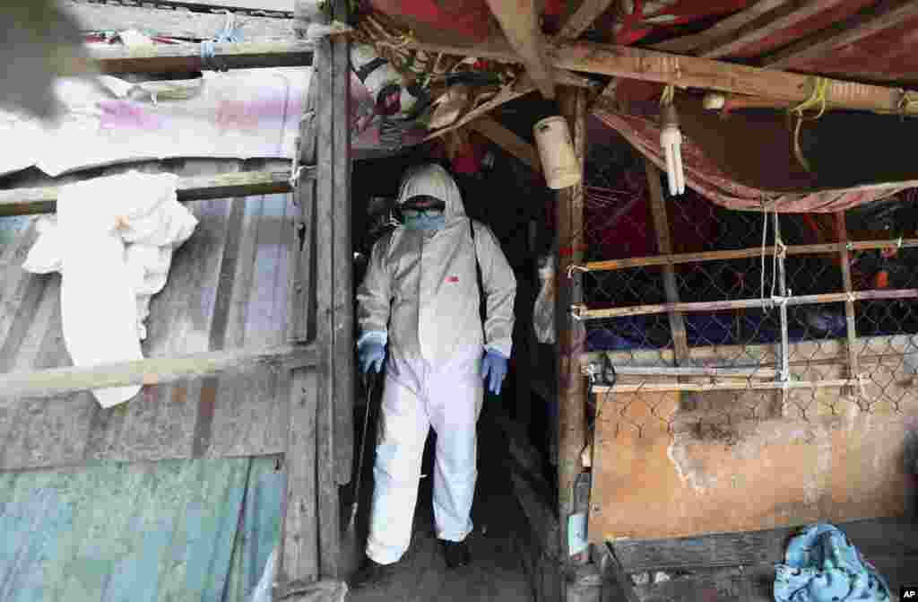 An employee of the non-profit Cambodian Children&#39;s Fund sprays disinfectant to help curb the spread of the new coronavirus in the slum neighborhood of Stung Meanchey in southern Phnom Penh, Cambodia, on Tuesday, March 24, 2020. (AP Photo/Heng Sinith)