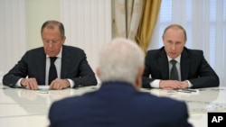 FILE - Syrian Foreign Minister Walid al-Mualem, front, meets with Russian President Vladimir Putin and Russian Foreign Minister Sergey Lavrov, left, in Moscow's Kremlin, June 29, 2015. 