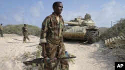 A Somali government soldier holds his weapon in the port of El-Ma'an a few hours after Somali and African Union forces ousted al-Shabab fighters from the area 32km northeast of Mogadishu, Somalia, Sept. 4, 2012. Elsewhere, the Kenyan Navy shelled Somalia's port town of Kismayo, the remaining stronghold of the al-Qaida-linked militants, in preparation for ground forces to capture the town. 