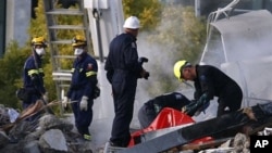 Emergency workers prepare to remove a body from the site of the CTV building in Christchurch, New Zealand, February 24, 2011, after the city was hit by a 6.3 magnitude earthquake Tuesday.