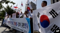 South Korean protesters shout slogans as they hold national flags during a press conference against abrupt cancellation by North Korea of planned reunions for families separated by the Korean War, Sept. 23, 2013.