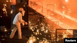 FILE - A laborer works at a steel plant of Shandong Iron & Steel Group in Jinan, Shandong province, China, July 7, 2017. Activity in China’s steel industry expanded in August at the fastest pace since April 2016.