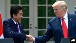 President Donald Trump and Japanese Prime Minister Shinzo Abe shakes hands during a news conference in the Rose Garden of the White House in Washington, June 7, 2018.