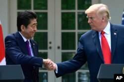 President Donald Trump and Japanese Prime Minister Shinzo Abe shakes hands during a news conference in the Rose Garden of the White House in Washington, June 7, 2018.