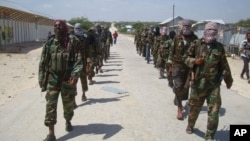 FILE - Members of Somalia's al- Shabab militant group patrol on foot on the outskirts of Mogadishu.