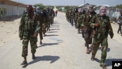 FILE - Members of Somalia's al- Shabab militant group patrol on foot on the outskirts of Mogadishu.