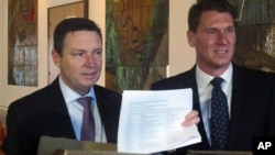 Australian Christian Lobby managing director Lyle Shelton, left, presents Australian Conservatives party leader Sen. Cory Bernardi, right, with 55,000 signatures on a petition at Parliament House in Canberra, Australia, Aug. 8, 2017. The petition demands a public vote on whether Australia should allow gay marriage. 