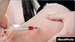 FILE - A women is seen performing an injection on herself.