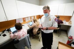 Sterling Heights Fire Department Chief Kevin Edmond works at a vaccine distribution location in Sterling Heights, Mich., Wednesday, April 28, 2021. (AP Photo/Paul Sancya)