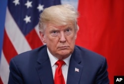 President Donald Trump listens to Japan's Prime Minister Shinzo Abe speak during their meeting, Nov. 30, 2018 in Buenos Aires, Argentina.