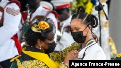 Rihanna Fenty (kanan) dianugerahkan dengan kehormatan Pahlawan Nasional ke-11 Barbados oleh Presiden Dame Sandra Mason (kiri) selama upacara Kehormatan Nasional dan Parade Hari Kemerdekaan di Golden Square Freedom Park di Bridgetown, Barbados, pada 30 November 2021. (Foto : AFP)