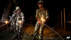 Indian Border Security Force soldiers place candles on a fence to celebrate Diwali, near the India-Pakistan international border area of Ranbir Singh Pora, about 33 kilometers (21 miles) from Jammu, India, Nov. 2, 2013. 