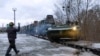 In this photo taken from video provided by the Russian Defense Ministry Press Service, a Russian armored vehicle drives off a railway platform in Belarus, Jan. 19, 2022.