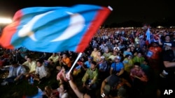 Supporters of former Malaysian strongman Mahathir Mohamad wave a flag during an election campaign in Kuala Lumpur, Malaysia, May 6, 2018.