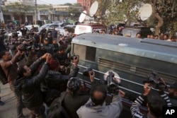 Surrounded by journalists and security forces, a prison van carrying Mohammad Imran, who is accused of the brutal killings of eight children in the eastern city of Kasur, arrives to a courthouse, in Lahore, Jan. 24, 2018. The Pakistani court has given police two weeks to interrogate the suspect.